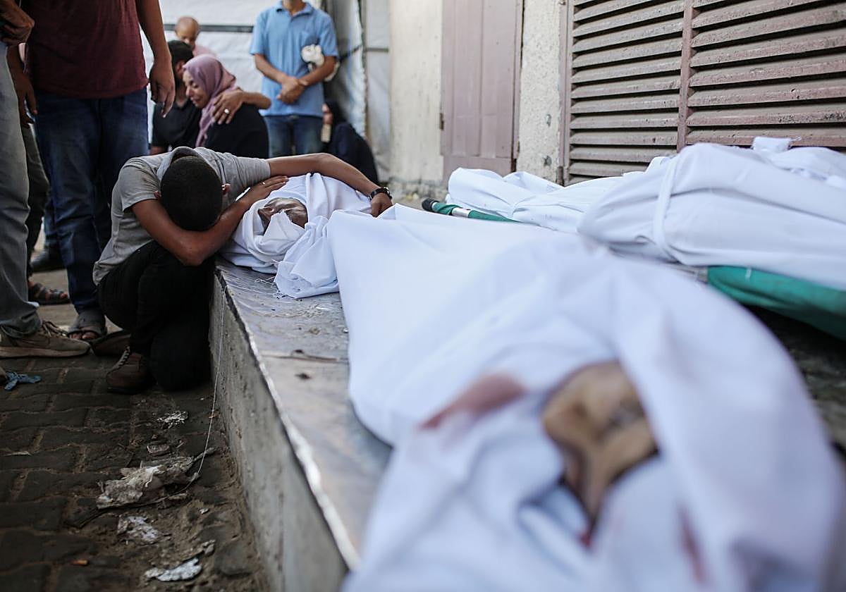 Un hombre llora junto al cuerpo de un familiar que murió en los ataques israelíes contra Deir al-Balah en Gaza.