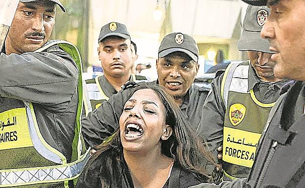 Agentes retienen a una joven manifestante.