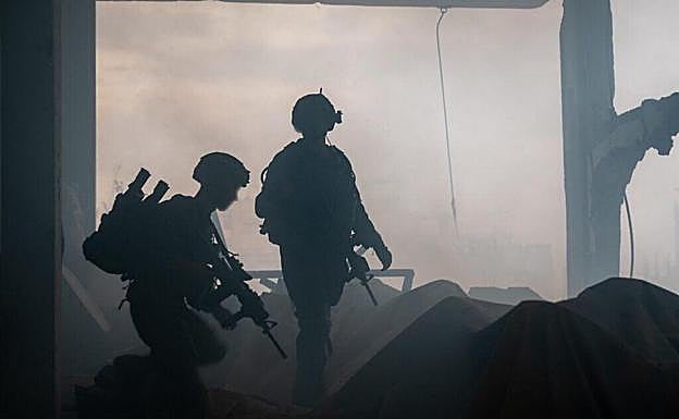 Dos soldados israelíes patrullan entre las ruinas de Gaza City.