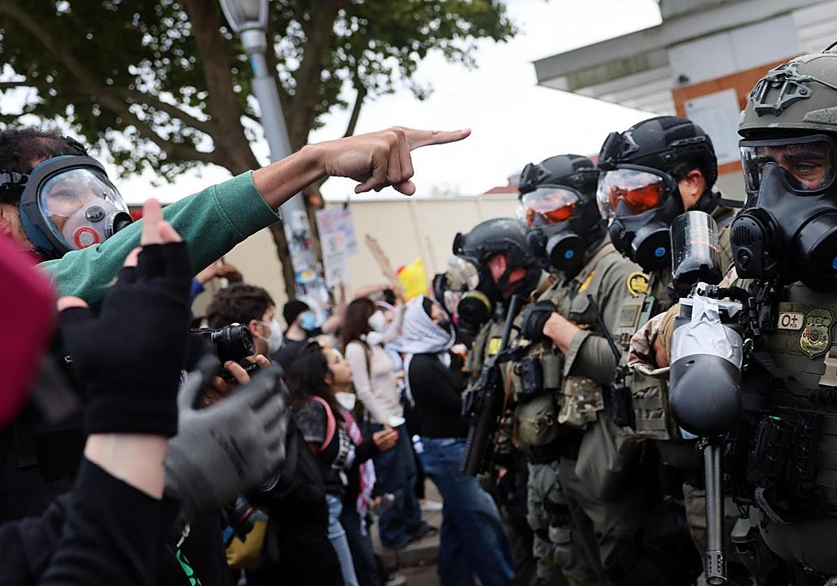 Agentes federales intentan contener a los manifestantes frente a un centro del Servicio de Inmigración en Portland.