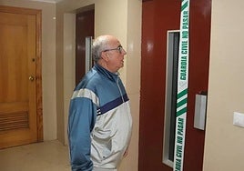 Un vecino observa el ascensor precintado por la Guardia Civil tras el siniestro mortal.