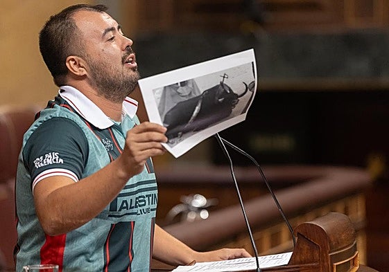 El diputado de Sumar Nahuel González, muestra una foto de un toro en una corrida en su intervención en el Congreso.