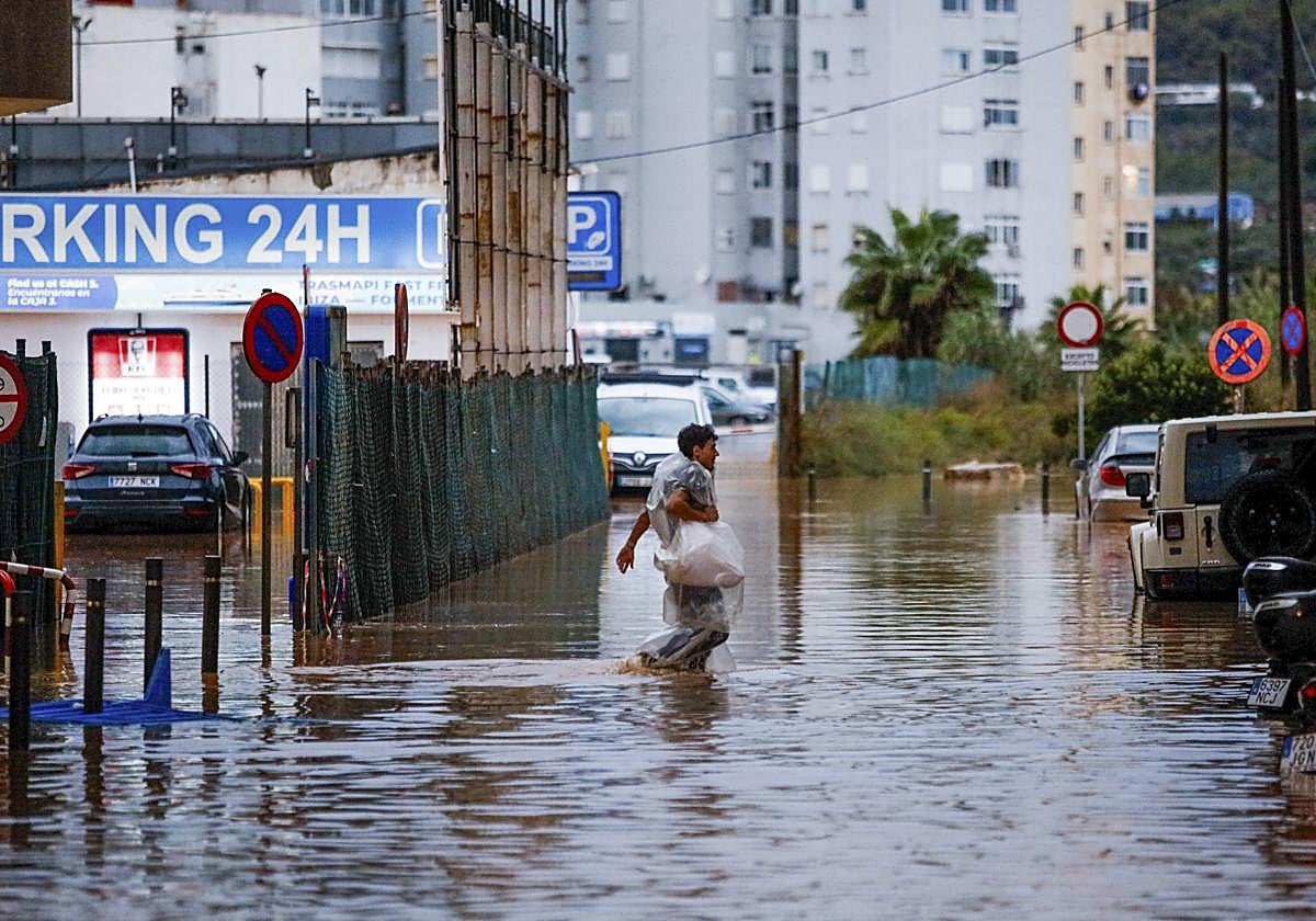 A man walks through flooded streets as a result of storm 'Alice'.