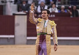 Morante de la Puebla, emocionado, se despide en el centro del ruedo de Las Ventas con la coleta en la mano.