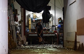 Una persona limpia los daños causados por la dana.