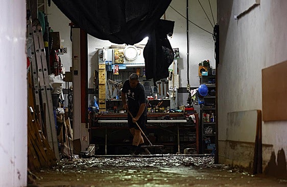 Una persona limpia los daños causados por la dana.