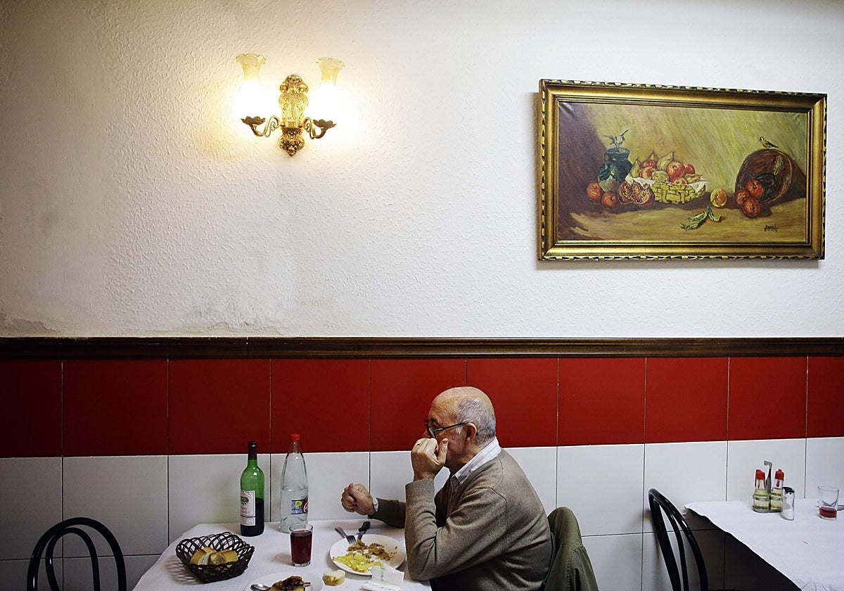 Un jubilado toma un menú en una casa de comidas.