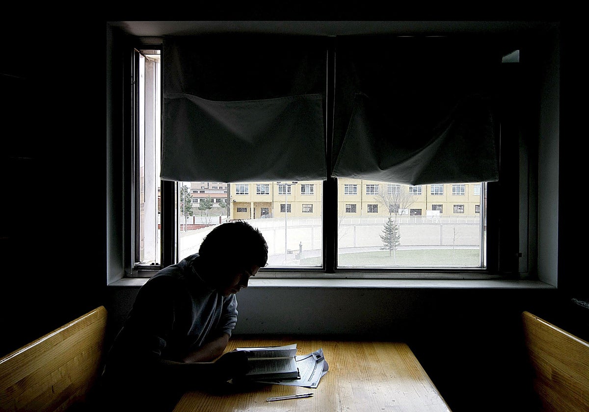 Un chico estudia en la sala de lectura de un centro español de protección de menores.