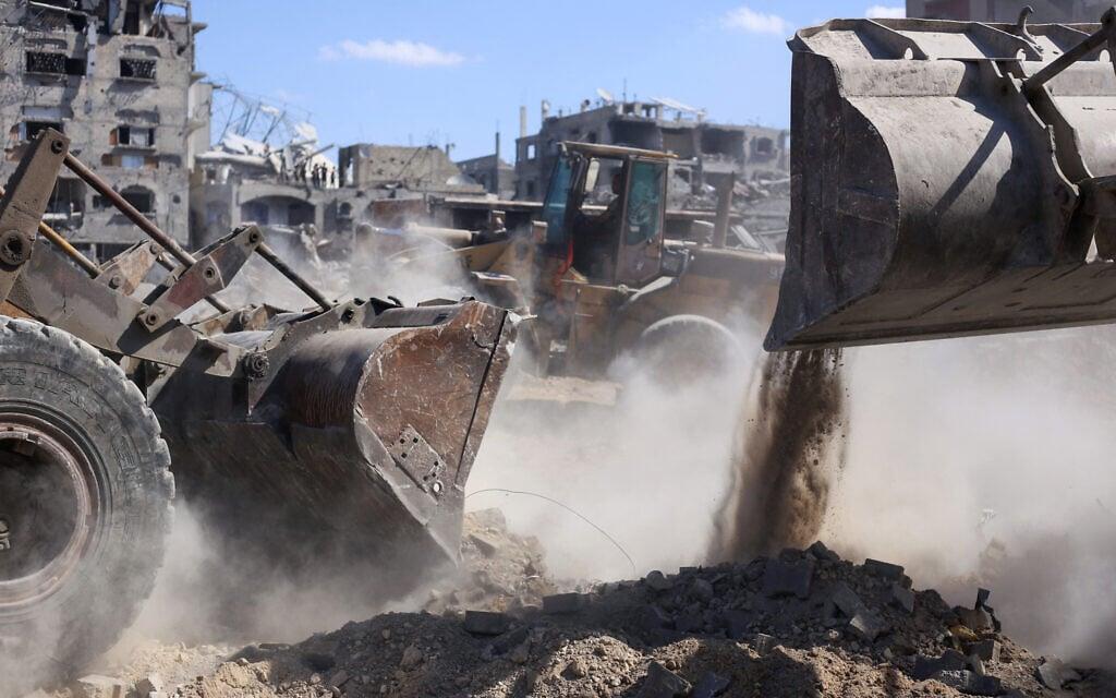 Las excavadoras tratan de limpiar una zona llena de escombros en el centro de la Franja.