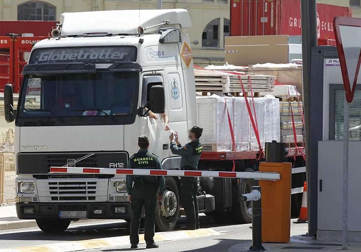 Un guardia civil comprueba la documentación de un camión en el puerto.