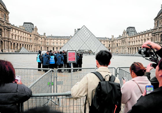 Personas junto a un cartel que dice: «El Museo del Louvre permanecerá cerrado hoy por razones excepcionales».