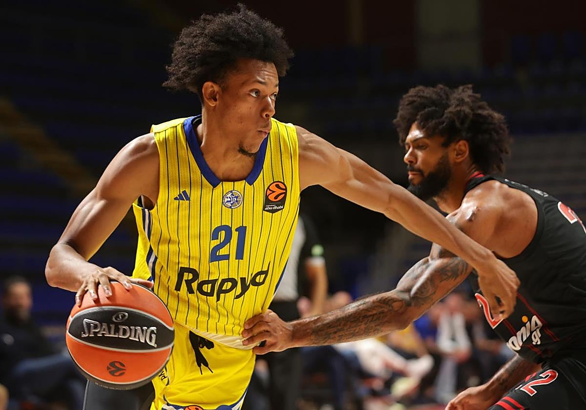 Jeffrey Dowtin Jr of Maccabi controls the ball against Tyler Dorsey of Olympiacos.