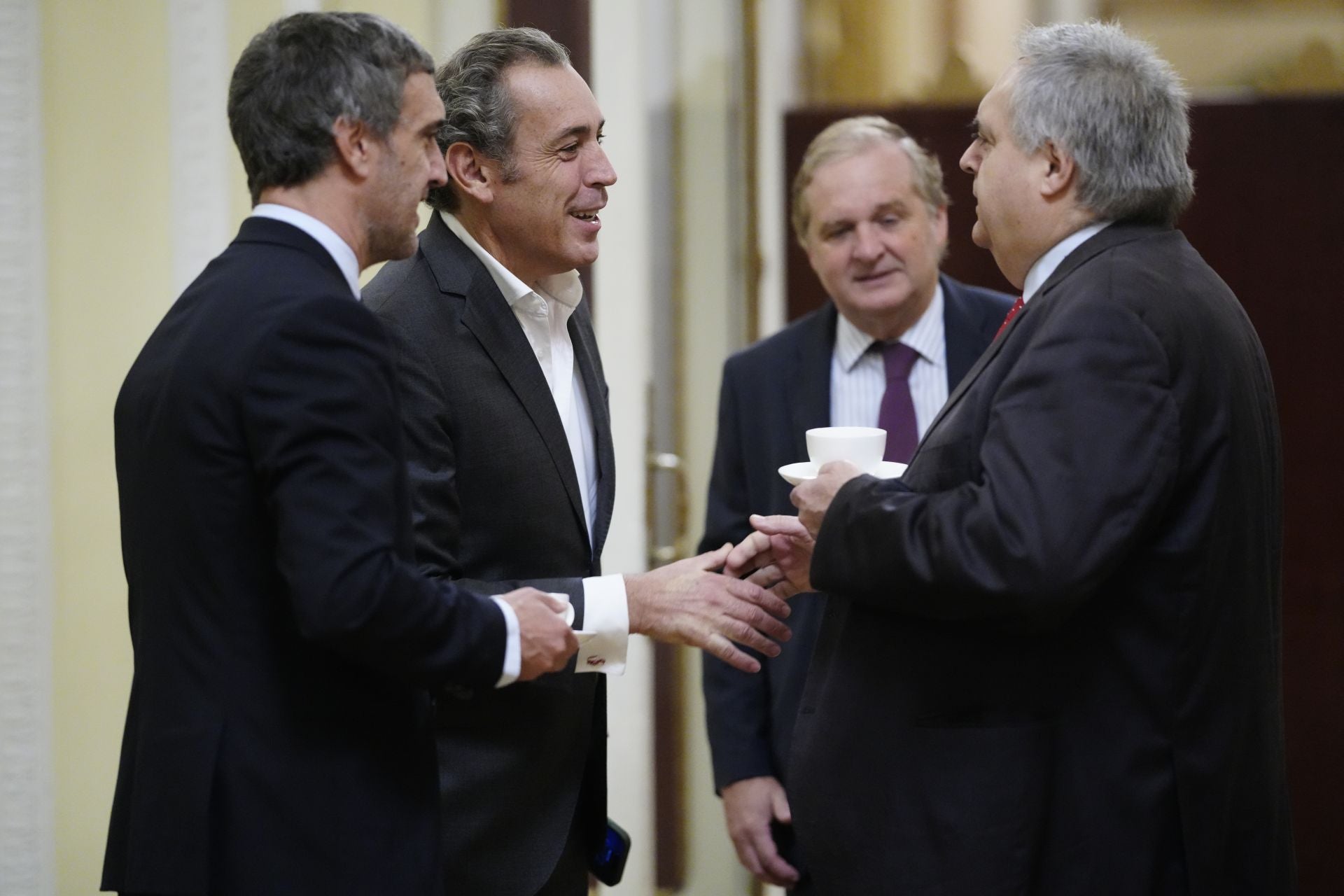 Fernando Belzunce, director general Editorial y de Comunicación de Vocento; Manuel Mirat, CEO de Vocento; e Ignacio Ybarra, presidente de Vocento, saludan a Txema Oleaga, senador del PSOE-PSV.