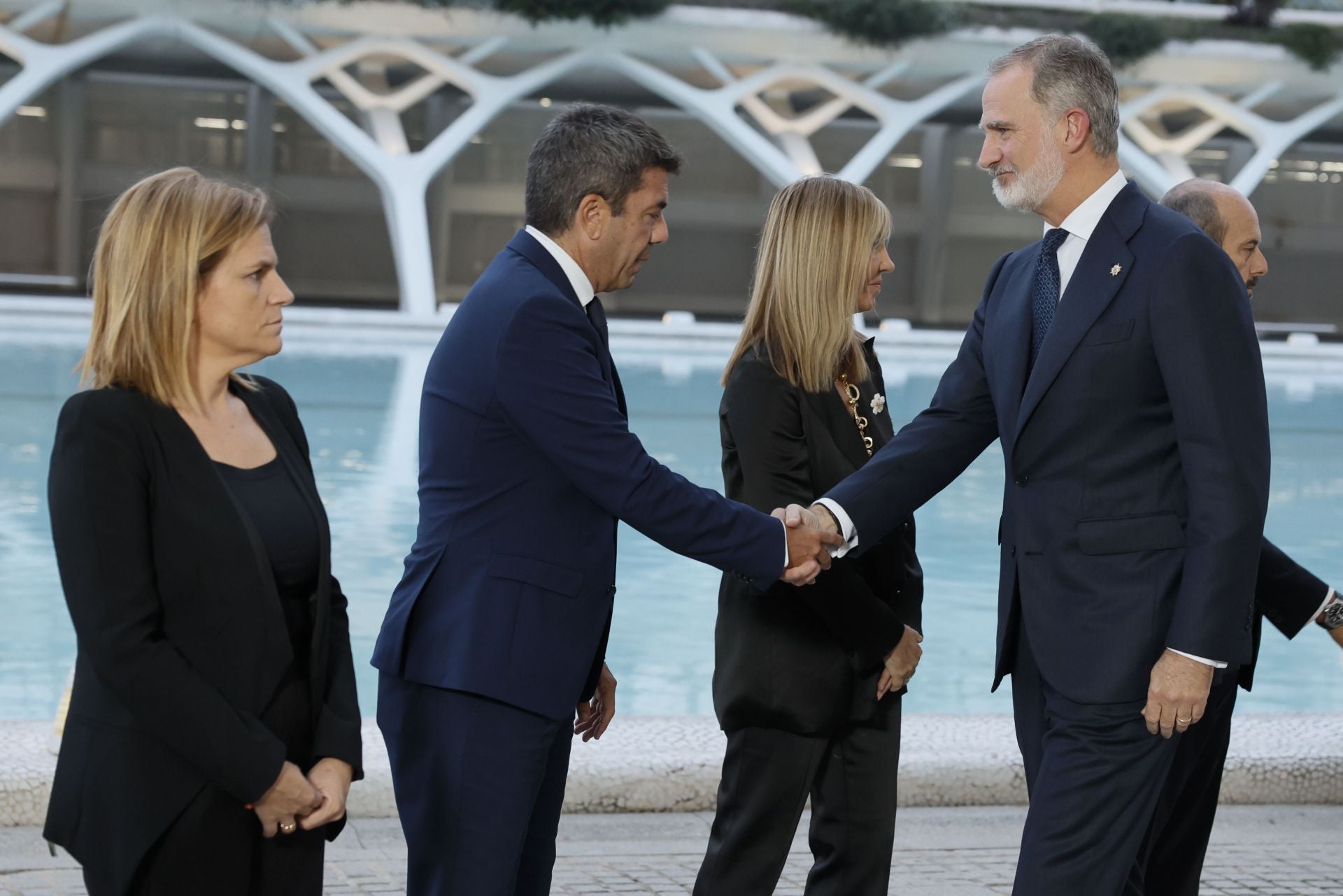 El rey Felipe VI saluda al presidente de la Generalitat Valenciana, Carlos Mazón , a su llegada al homenaje de Estado.