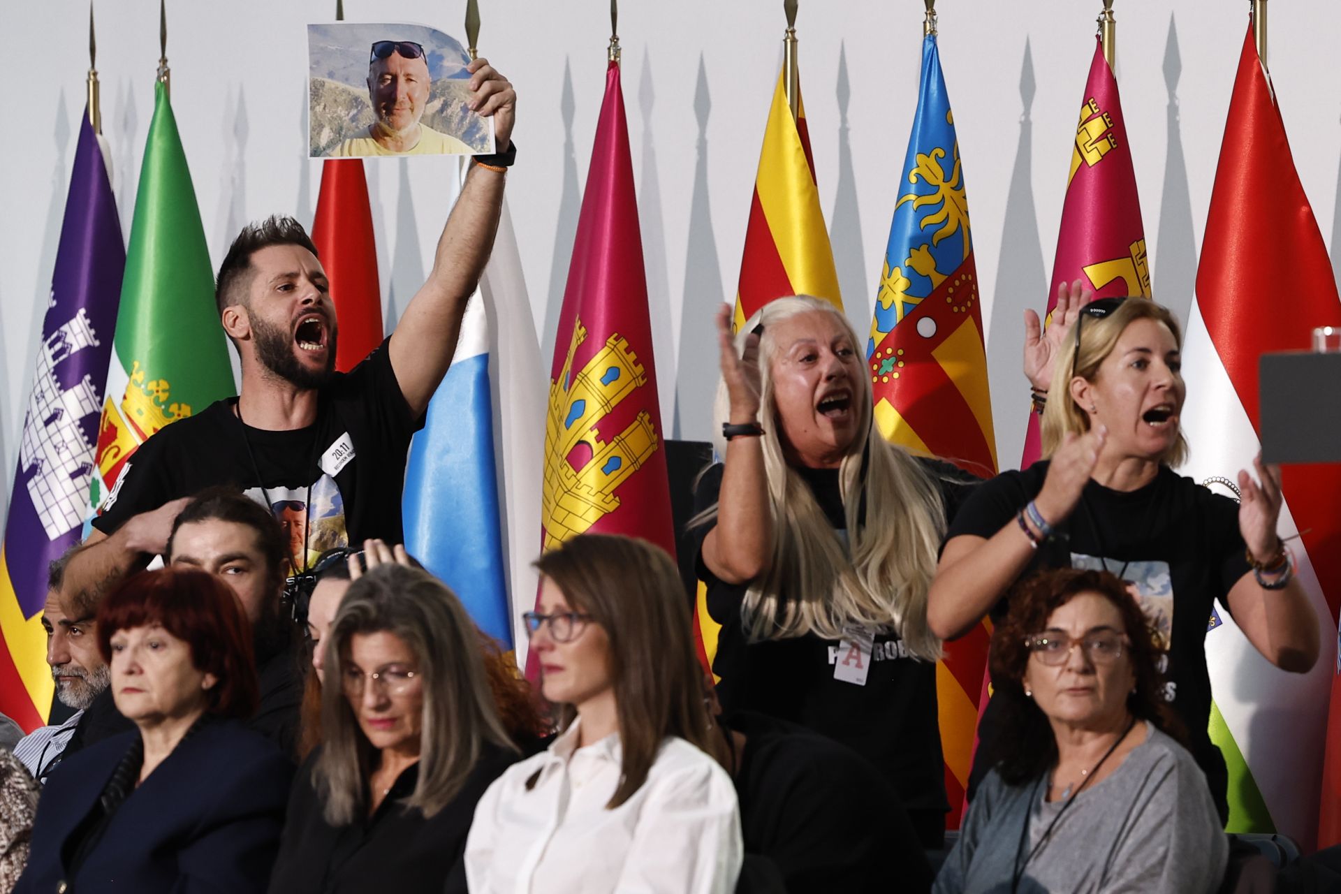 Varios de los familiares de las 237 víctimas de la dana muestran fotografías de los seres queridos fallecidos.