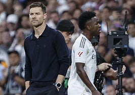 Vinicius pasa junto a Xabi Alonso tras ser sustituido en el clásico.