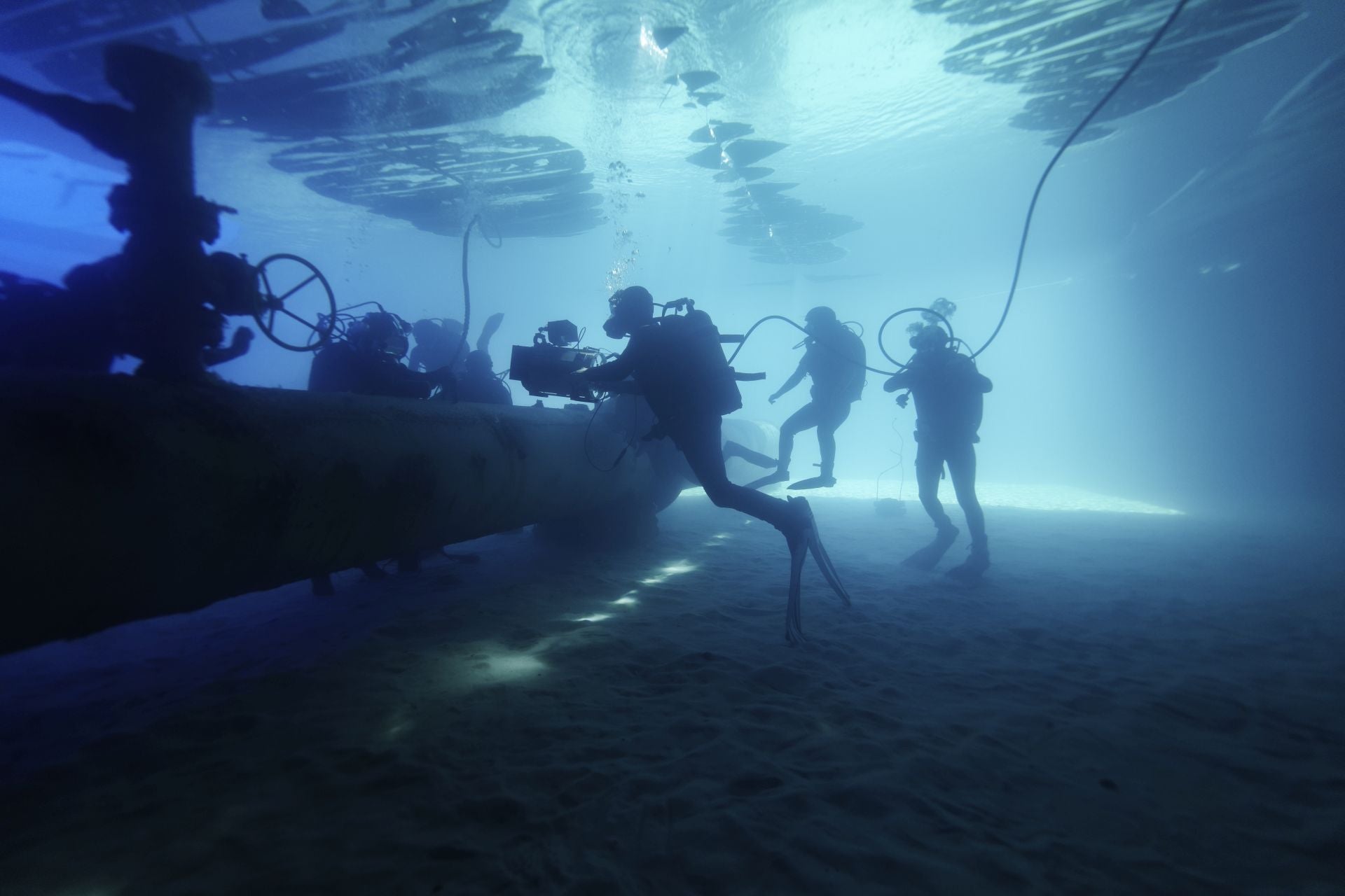 Imagen principal - Arriba, una imagen del rodaje bajo el abua; debajo, Alberto Rodríguez da indicaciones a De la Torre y Bárbara Lennie y una imagen de ambos en la película.
