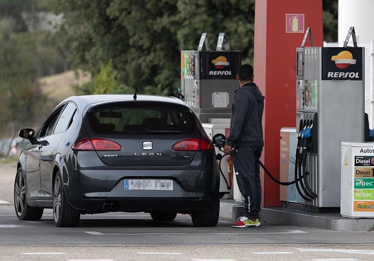 Un hombre repostando en una gasolinera.