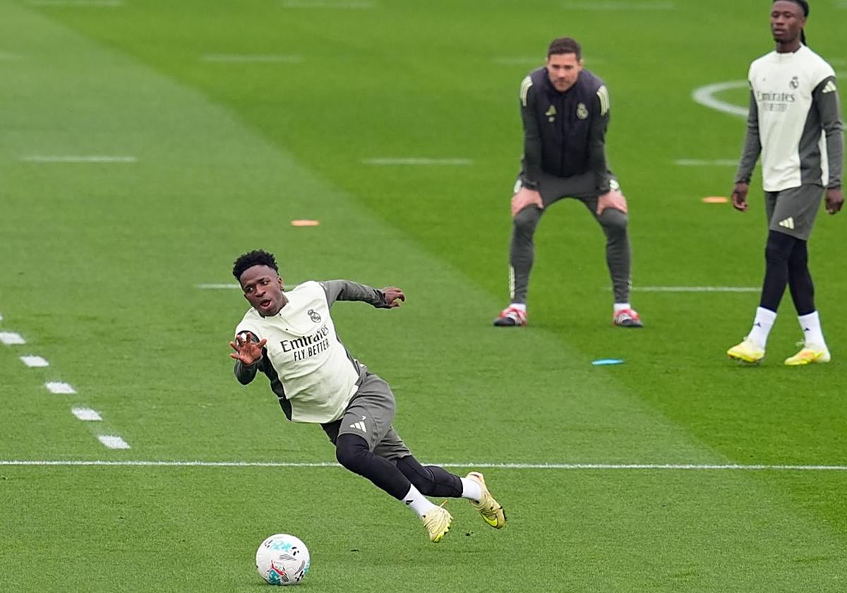 Vinicius slips under the watchful eye of Xabi Alonso during Friday's training session.