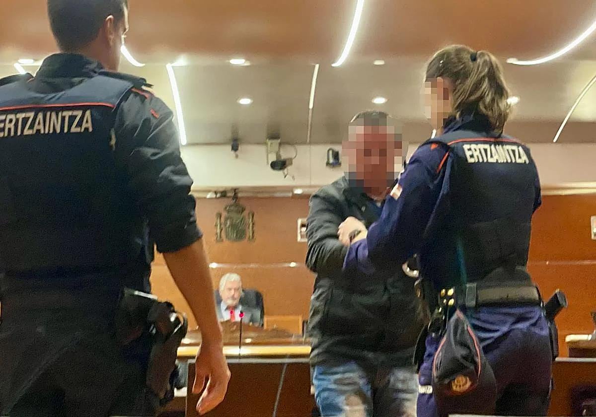 Una ertzainza quita las esposas a este procesado en el juicio celebrado en la Audiencia Provincial hace ahora un año.