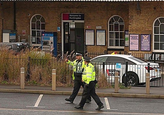 Agentes de policía caminan fuera de la estación de Huntingdon.