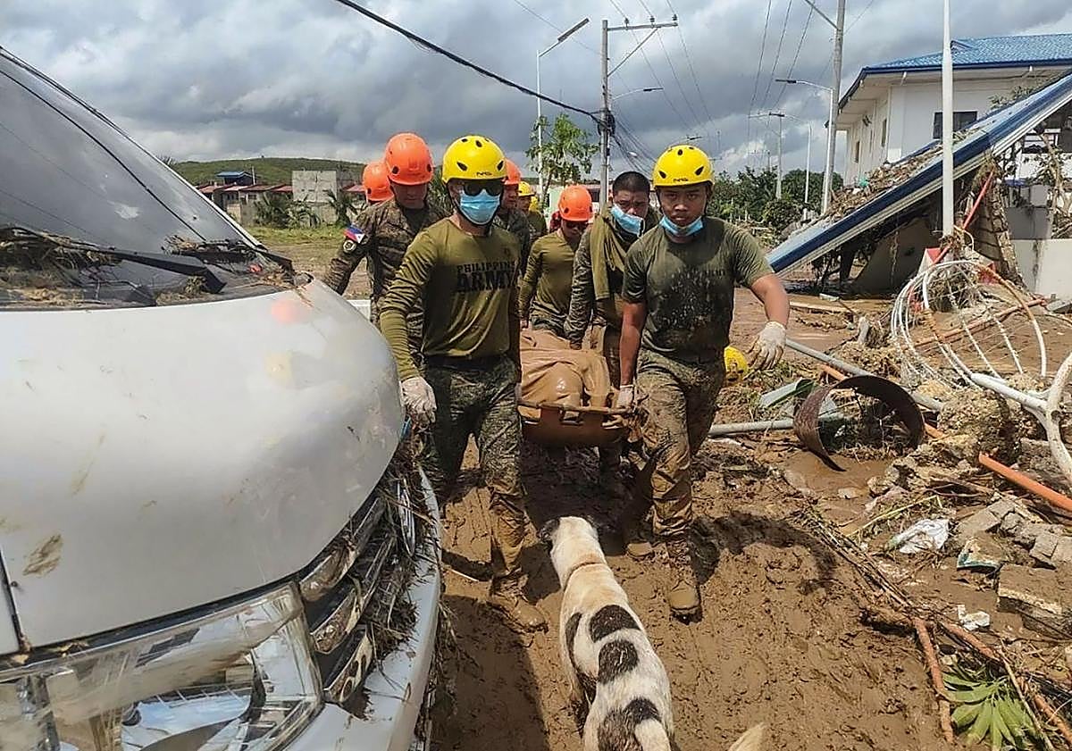 Imagen principal - El ejército filipino traslada a una víctima en camilla en la localidad de Liloan; las olas azotan la playa de Quy Nhon antes de la llegada del tifón a la provincia de Gia Lai (Vietnam); vehículos amontonados tras el paso de 'Kalmaegi' por la ciudad de La Carlota (Filipinas.)