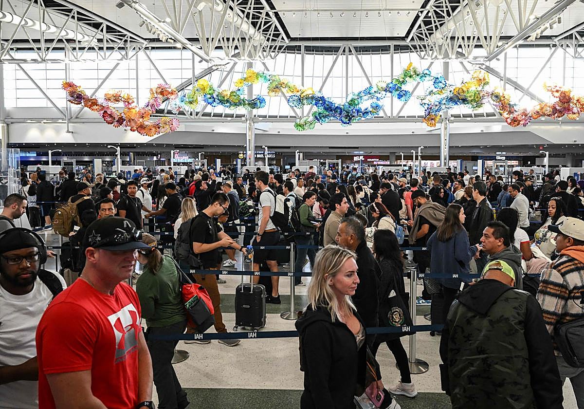 Pasajeros forman largas filas para pasar el control de seguridad en el aeropuerto de Houston.
