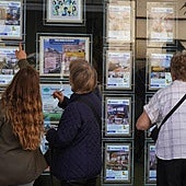 Varias personas mirando anuncios de viviendas.