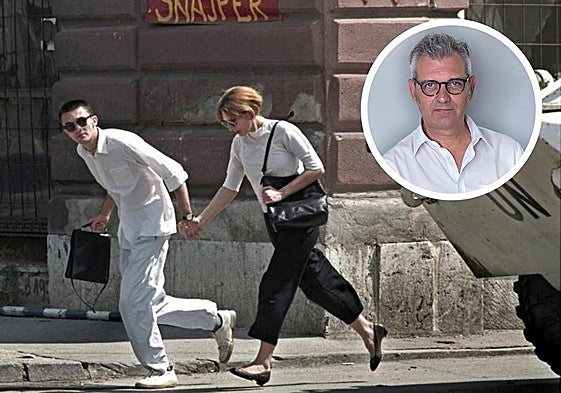 Una pareja corre por una calle de Sarajevo en pleno asedio de la capital bosnia. En la parte superior de la foto, el escritor Ezio Gavazzeni.