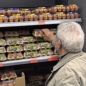 Un hombre compra huevos en un supermercado.