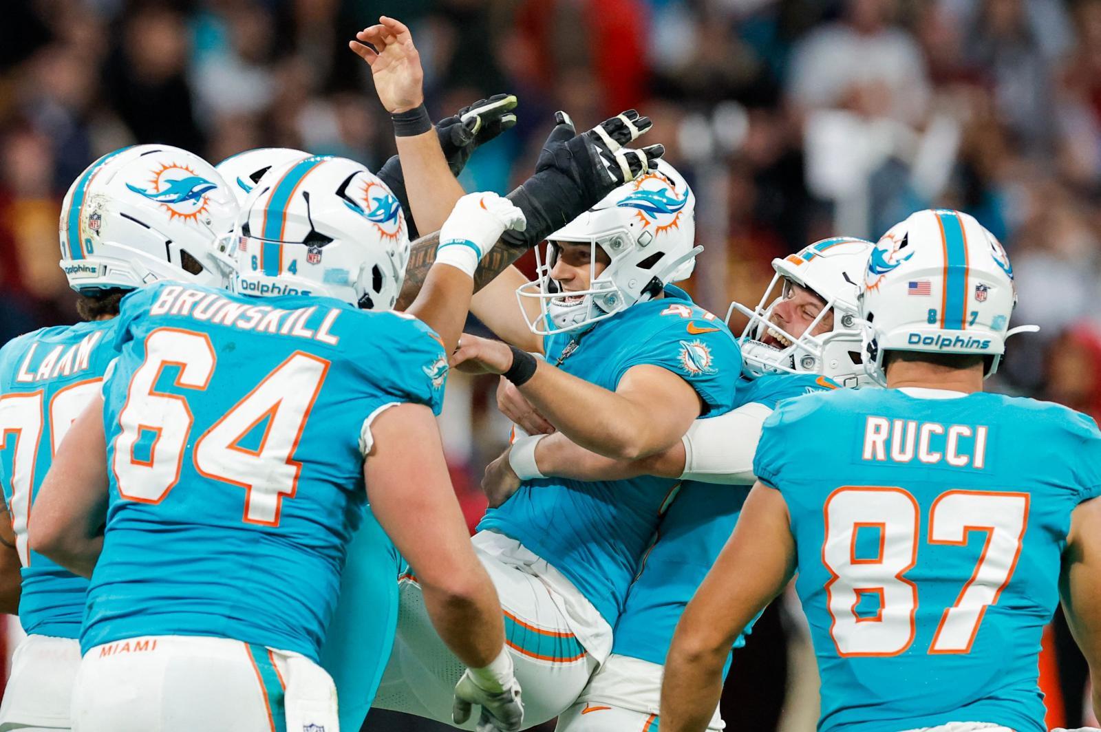 Los jugadores de los Dolphins celebran con patterson la victoria.