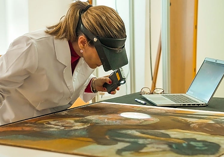 Restauradora supervisando la capa pictórica de la obra 'En la sombrerería', de Degas.