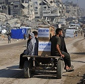 Una familia palestina transporta ayuda humanitaria en Gaza.
