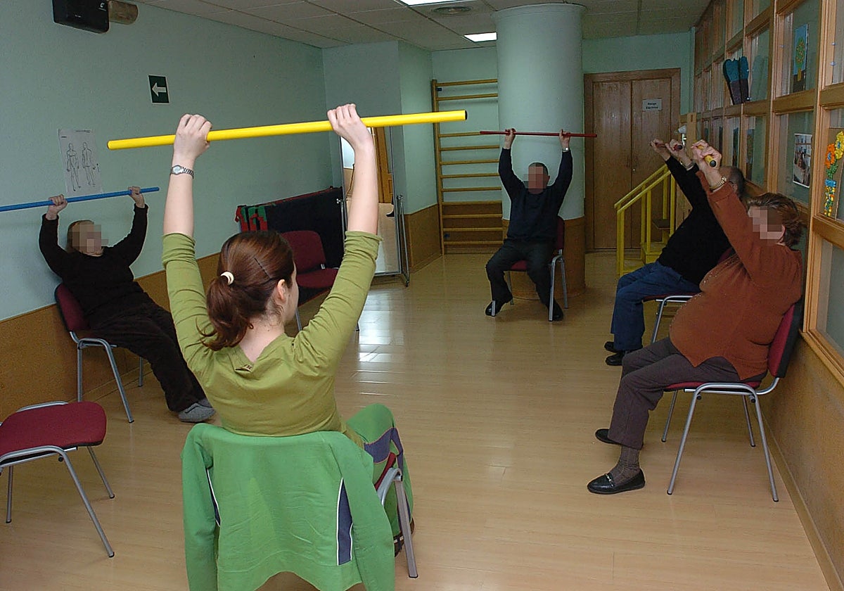 Una monitora dirige un ejercicio de rehabilitación para personas con alzhéimer.