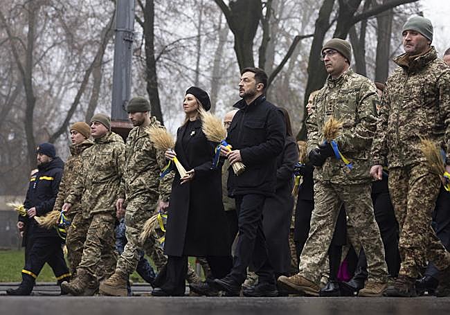 Zelenski y su mujer hacen una ofrenda rodeados de soldados ucranianos.