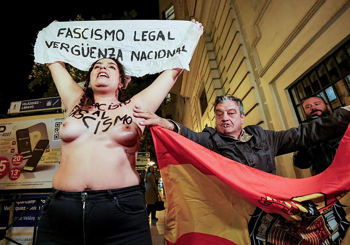 Un hombe, con una bandera preconstitucional, junto a las activistas de Femen.