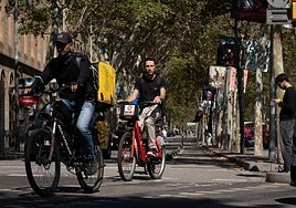 Dos personas circulan con bicicleta eléctrica por Barcelona