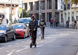 Dos patinetes eléctricos circulan por la calle Angustias de Valladolid.