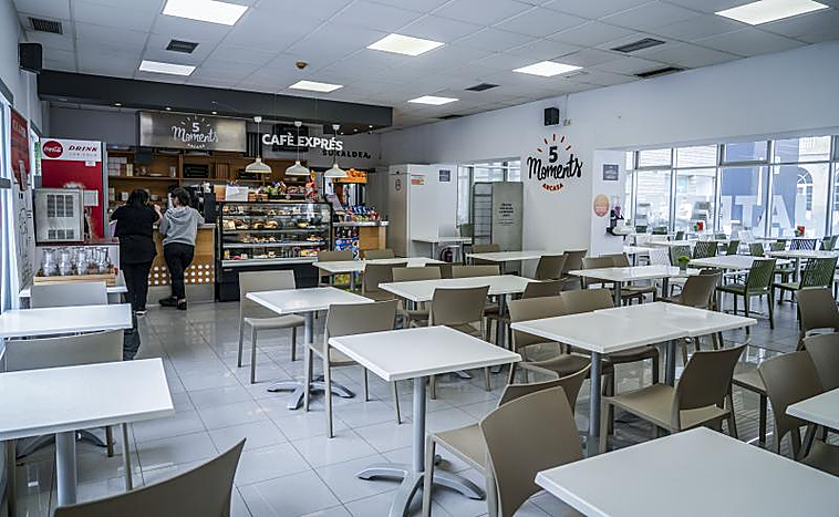 Dos clientes piden en la barra de la cafetería de un hospital