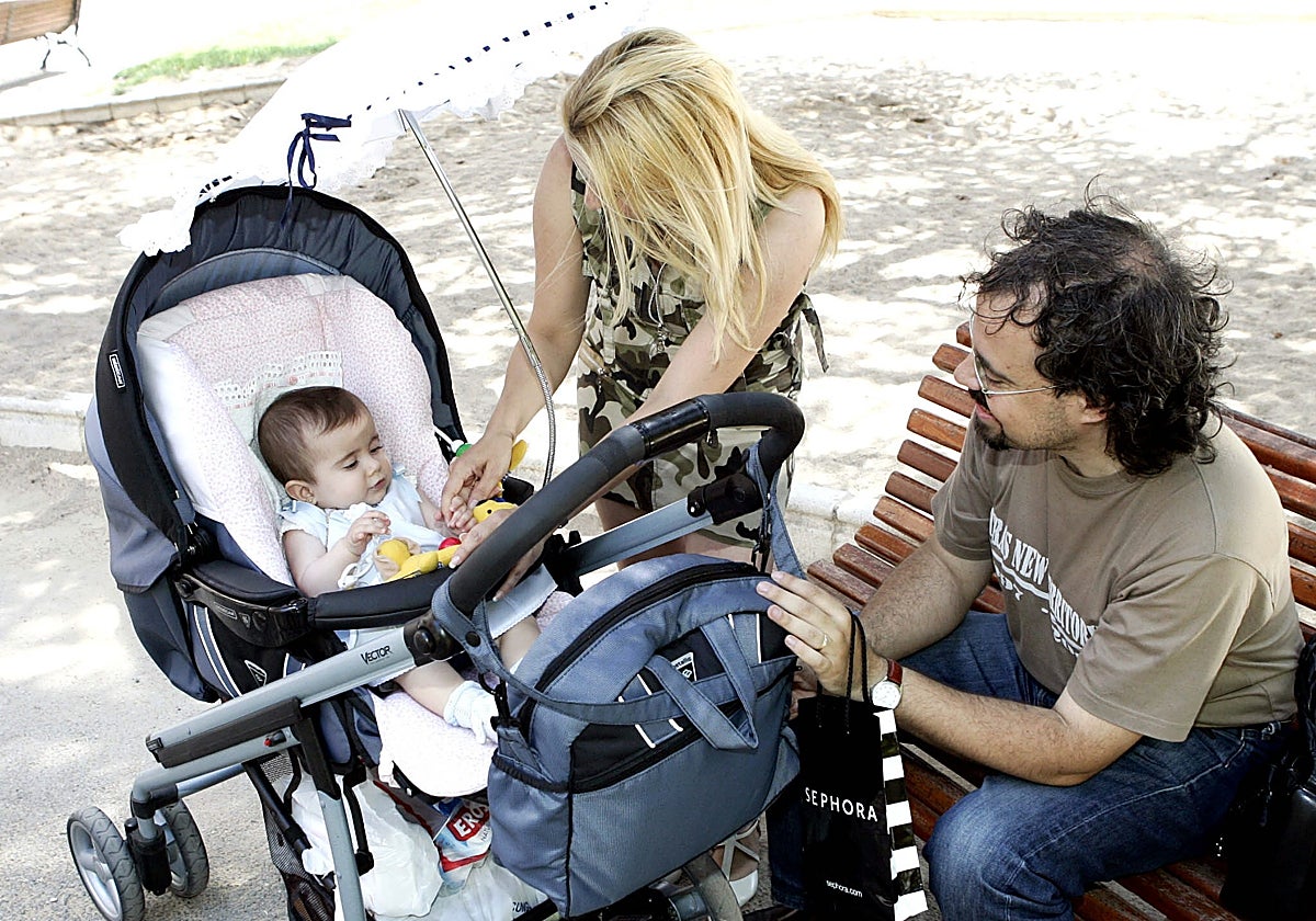 A couple attends to their baby in a park.