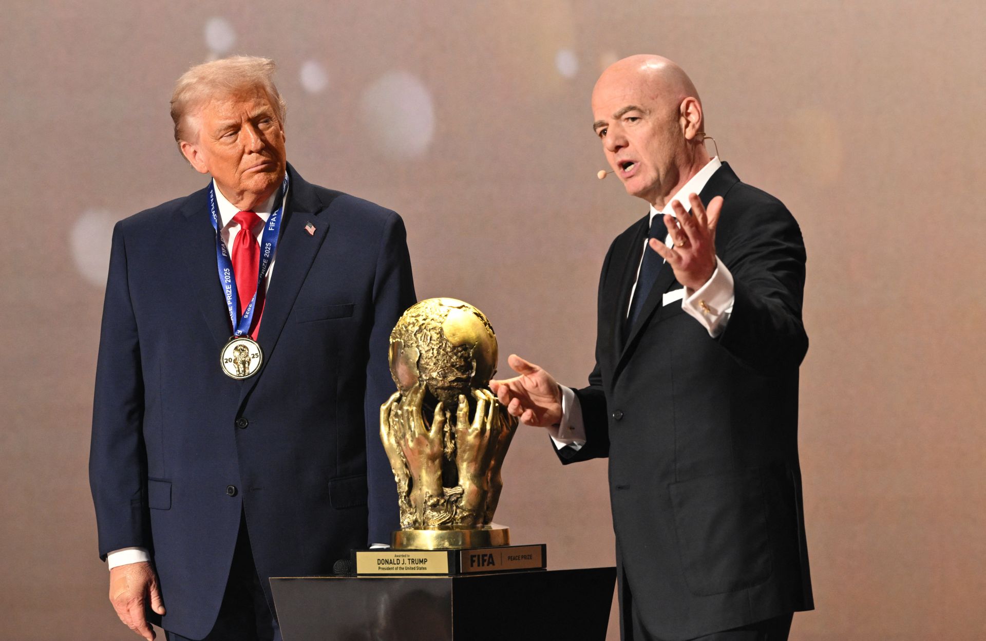 Gianni Infantino se dispone a entregar el premio FIFA de la Paz a Donald Trump.