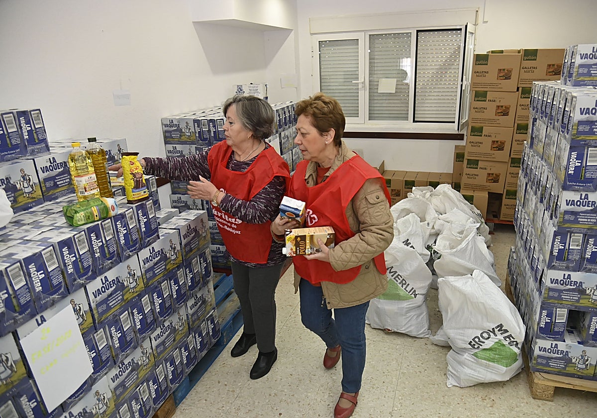 Dos voluntarias de Cáritas ordenan parte de los alimentos donados a la organización.