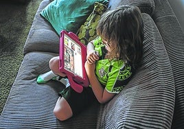 La foto, tomada en octubre, muestra a un niño de seis años sentado en un sofá con su iPad viendo un programa de YouTube en su casa del oeste de Sídney.