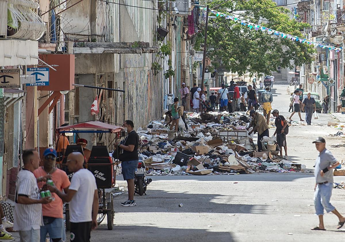 Imagen principal - Los cubanos conviven con montañas de basura, a las que a menudo pegan fuego. El Gobierno usa presos para retirarla allí donde llega el combustible.