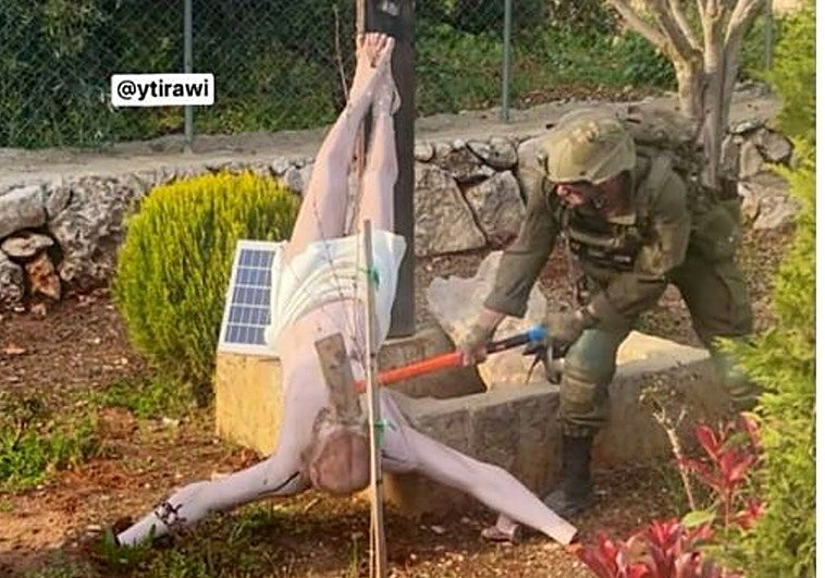 Un soldado israelí derriba a mazazos una estatua de Jesús en Líbano