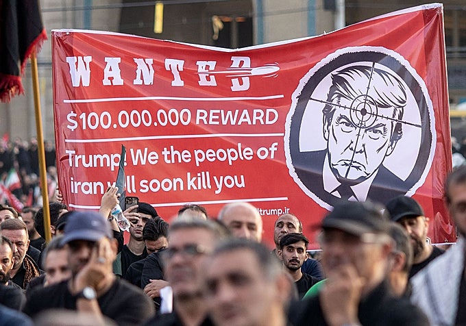 En el funeral abundan las pancartas contra Trump.