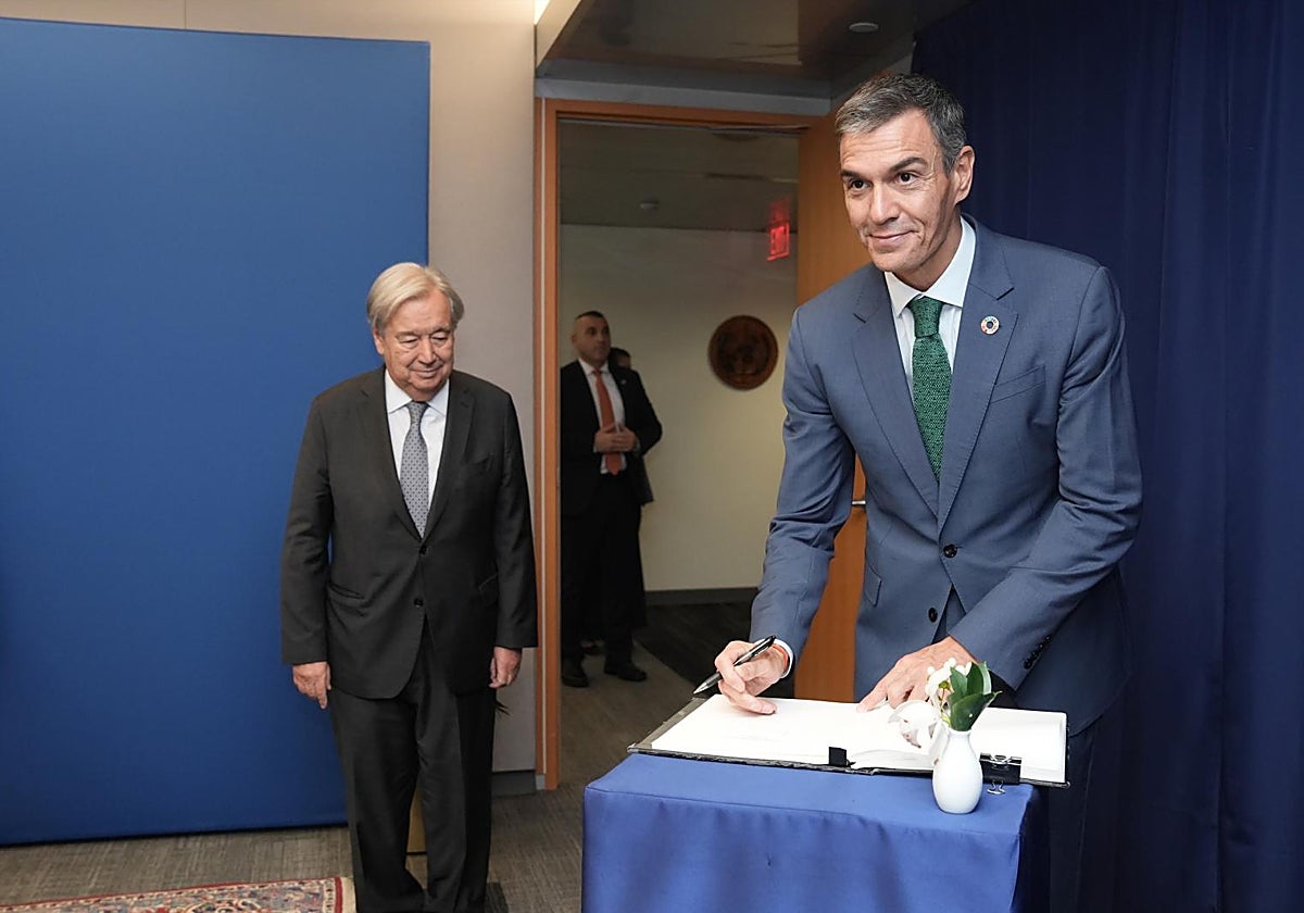 Pedro Sánchez firma el libro de visitas de la ONU delante de su secretario general, Antonio Guterres.