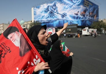 Una mujer iraní se manifiesta en Teherán con una imagen del fallecido ayatolá Ali Jamenei.
