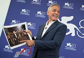 George Clooney, sujetando una fotografía de una visita suya anterior a la Mostra de Venecia.
