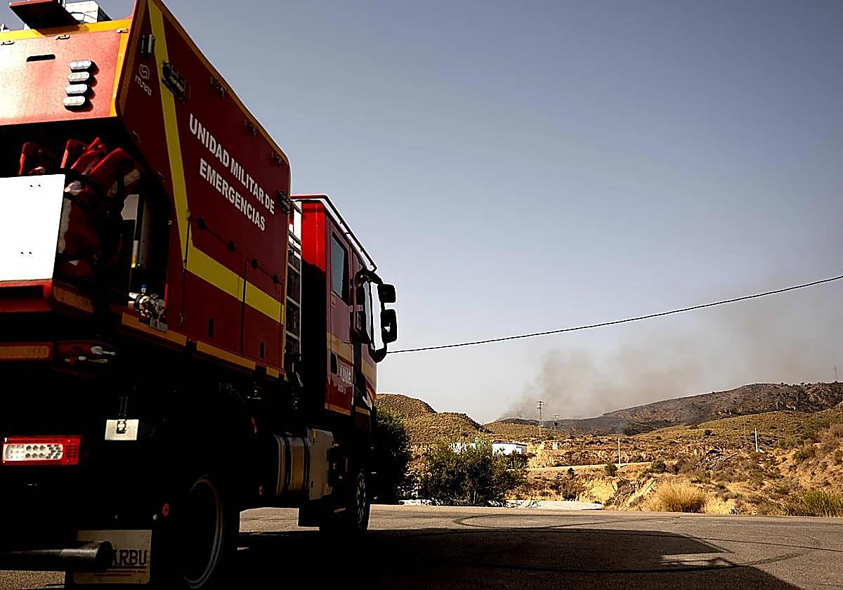 Una autobomba de la UME va hacia el frente del fuego.
